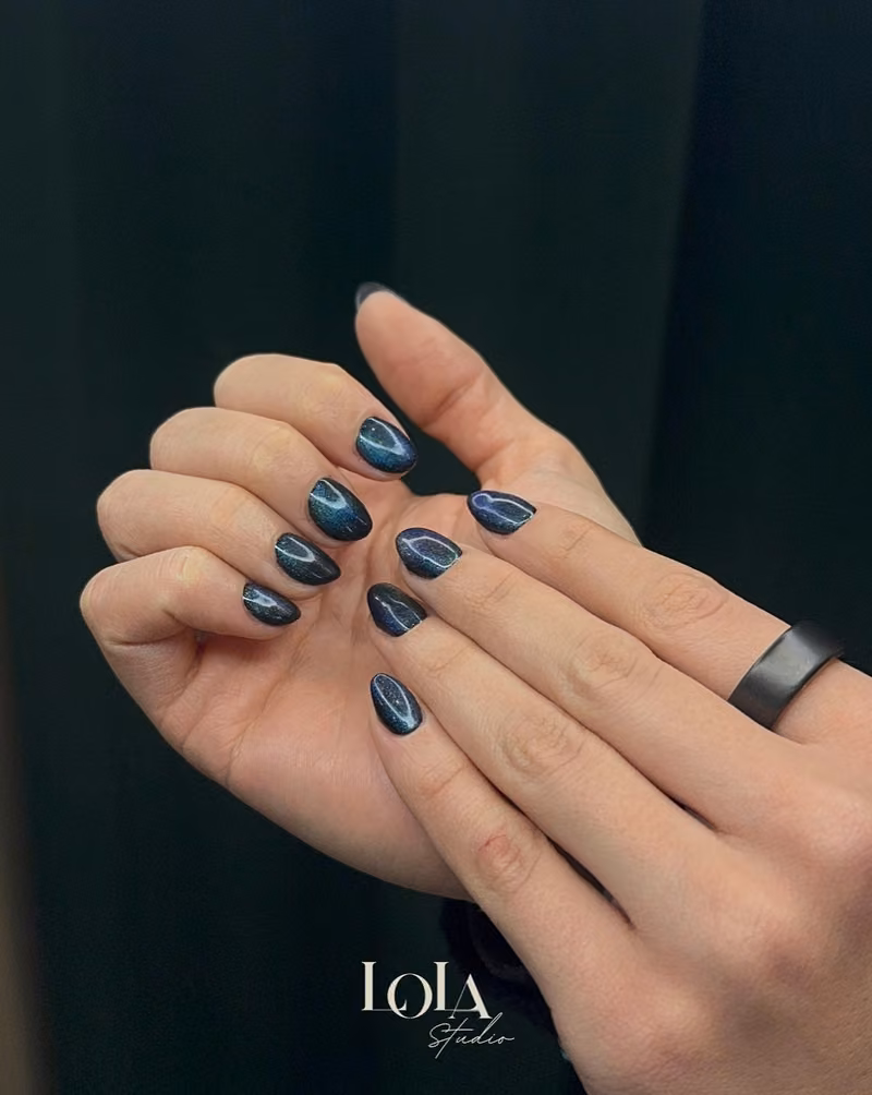 Uñas azul noche con efecto ojo de gato